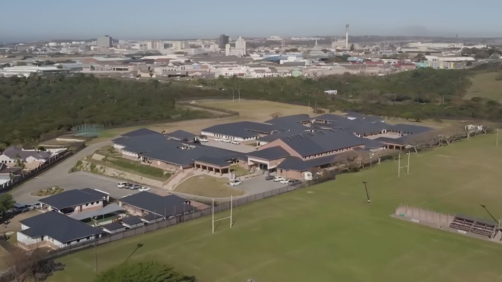 Ooskus Gimnasium skool en sportvelde met Oos-Londen stadsgebied in die agtergrond.